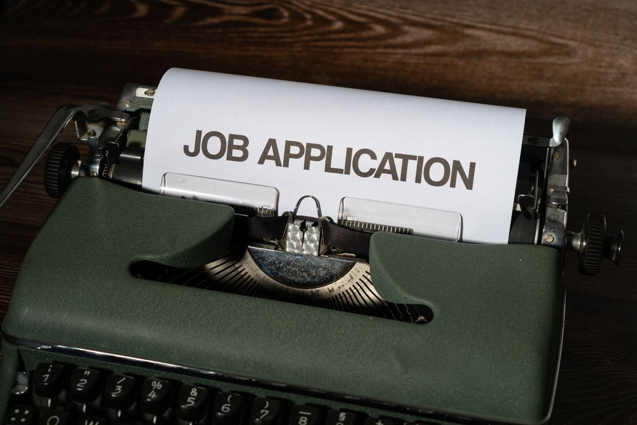 Close-up of a vintage typewriter with a job application paper inserted.
